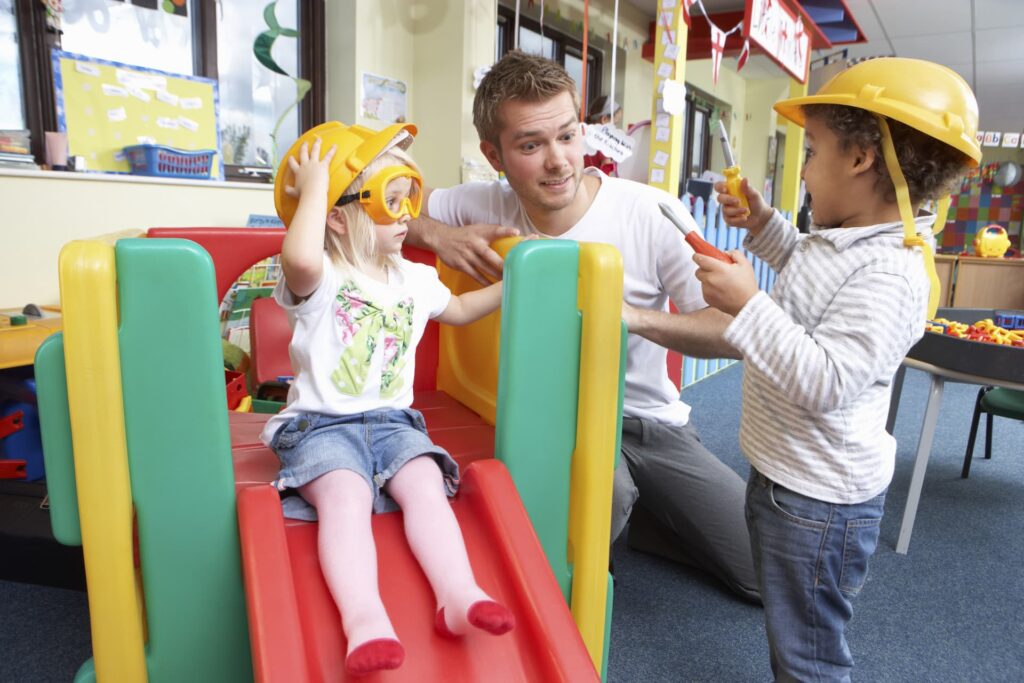 A man working with children in a nursery