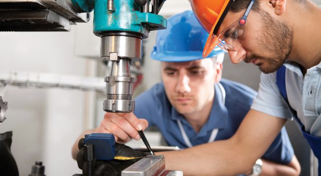 Two men working on a drill