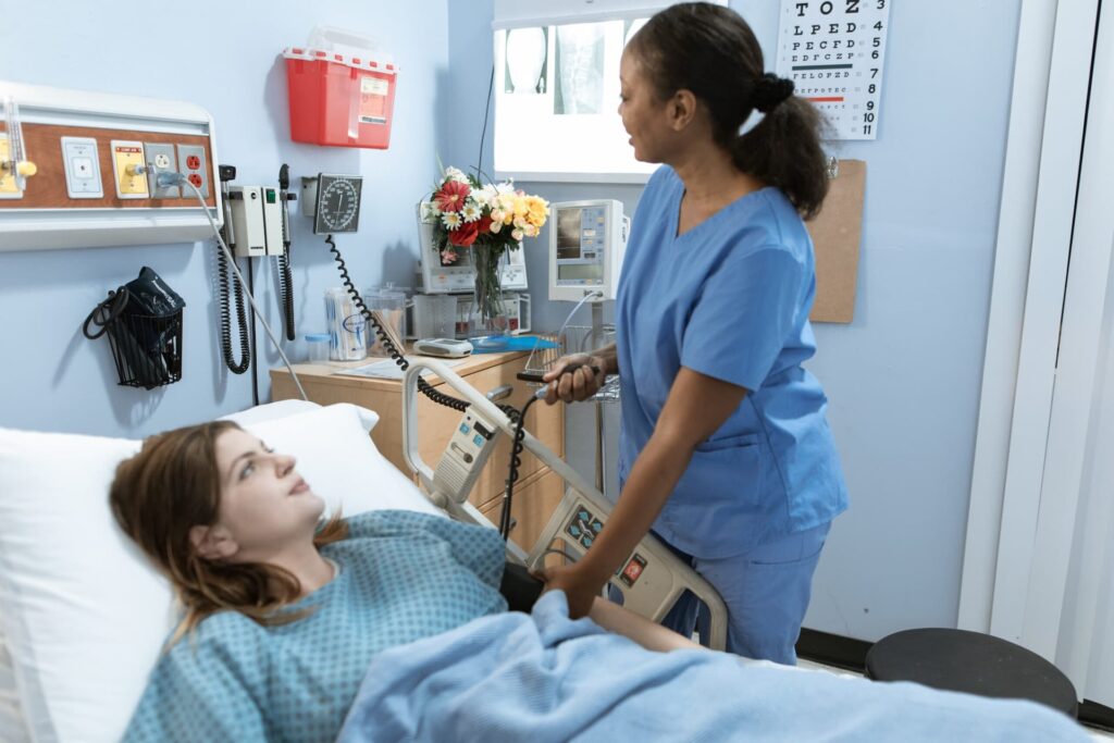 Nurse taking blood pressure in hospital bed